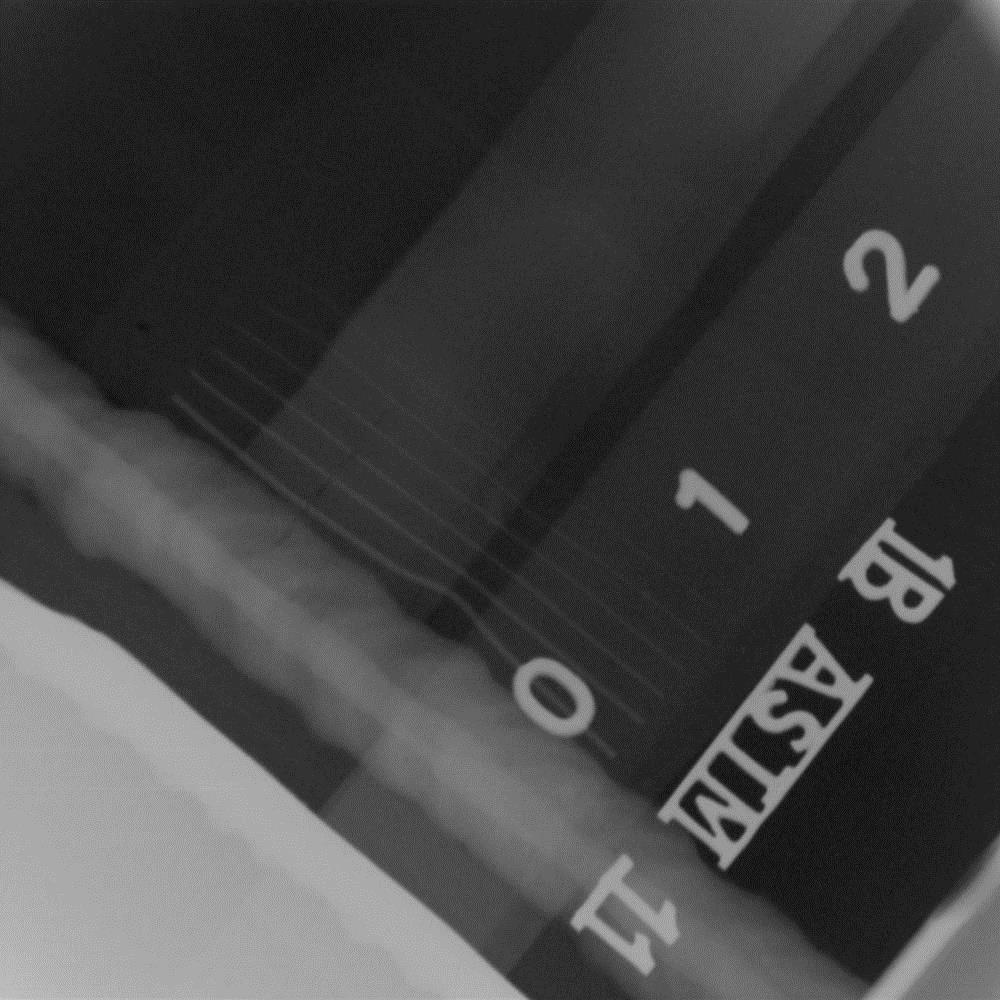 Radiograph of sample # 7497 showing linear imperfection in center of longitudinal seam weld and girth weld