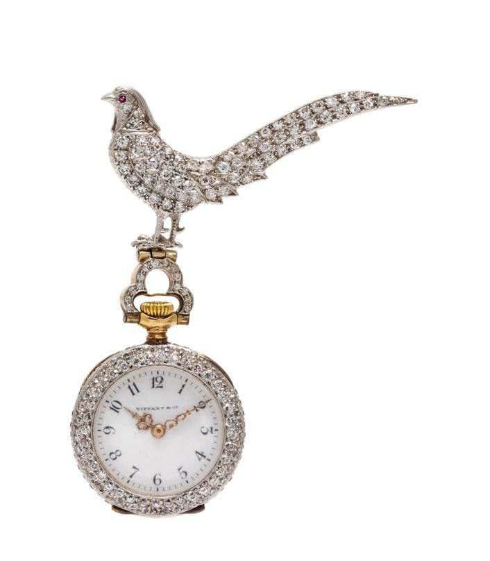 Sale 421 Lot 144 A Platinum, Diamond, Ruby and Yellow Gold Open Face Lapel Watch, Tiffany & Co.