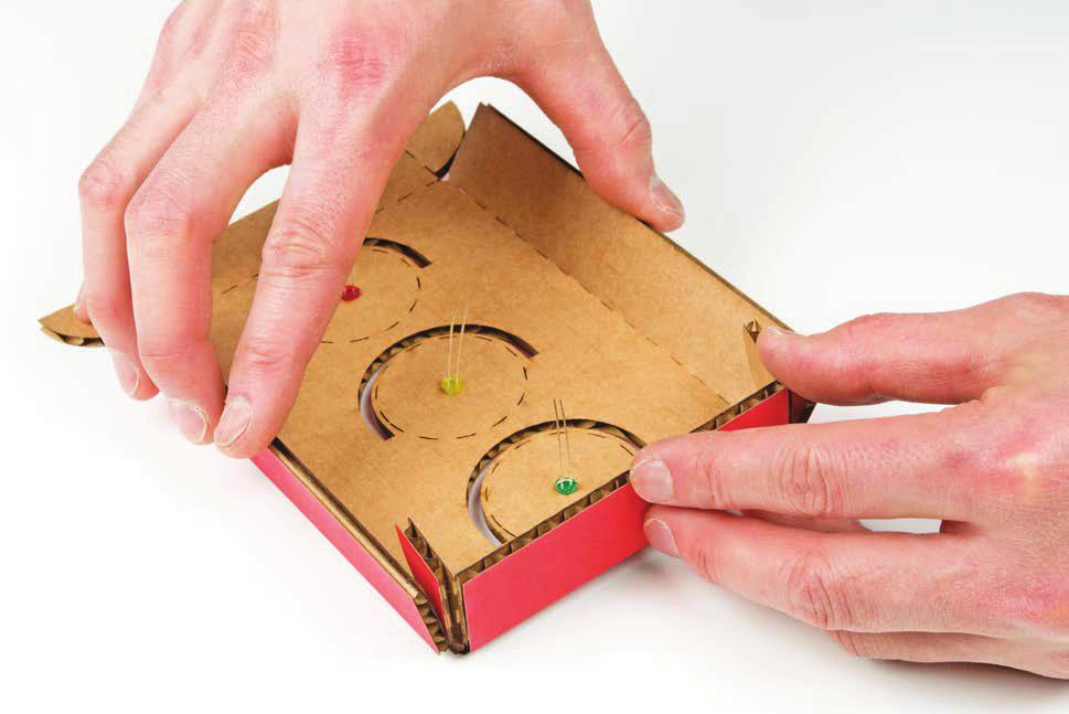 ) FIGURE 2-19: Prefolding the scored cardboard to form an enclosure for the Stoplight Position the tabs inside the vertical sides, and glue them in place as shown in Figure 2-20.