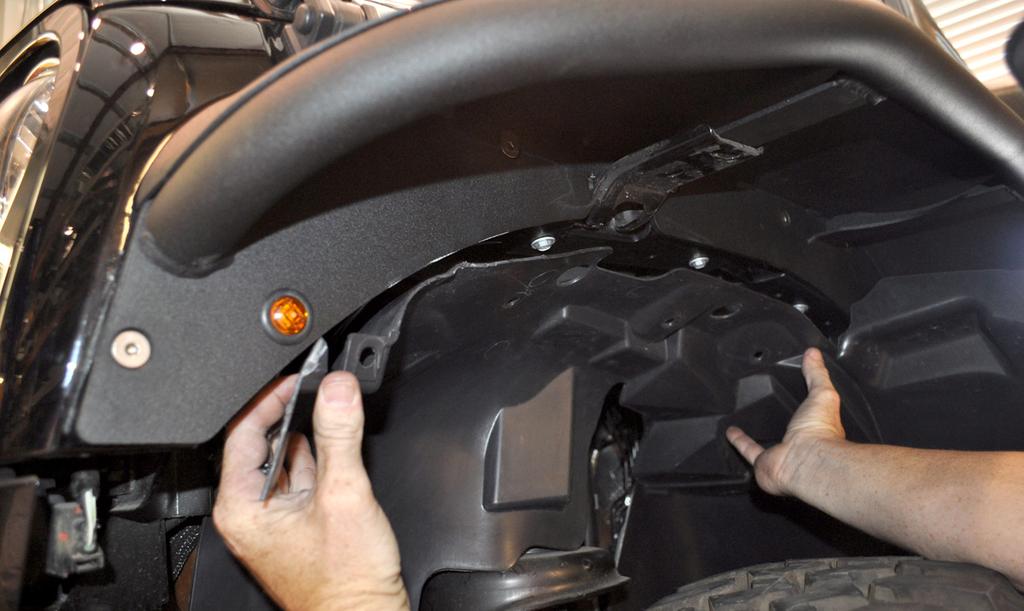 Begin by holding the plastic inner fender up in the wheel well, as close to its mounting position as possible. Use a fine-tip felt marker to designate your initial rough cut lines.