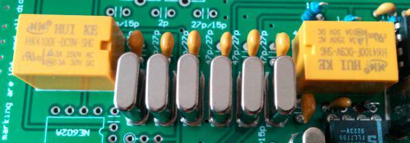 You don't need to place insulators under the crystals or ground the crystal cases Solder 7 each 47 pf capacitors Solder 2 each relays. When finished, it will look like the photo below Plug in a 12~13.