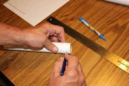 To ensure a square cut around the tube, wrap the straight edge of a strip of