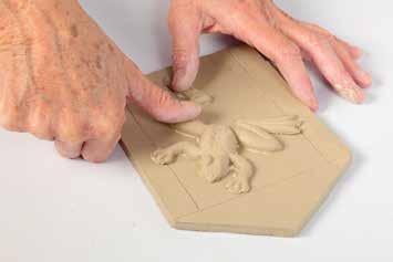 Attach appliquéd clay piece inside of marked lines on the