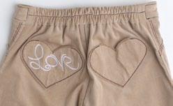 WIDE LEG STRETCH COTTON WHALE BONE CORDUROY PANTS WITH LOVE APPLIQUE IN SAND.