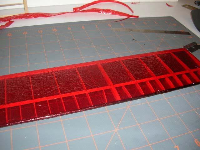 heat of the iron will activate the glue and the mylar will stick. Pull the mylar to the end of the trailing edge and tack down.