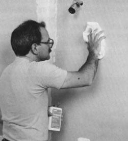 Clean the wall. Use a cloth moistened with denatured alcohol.