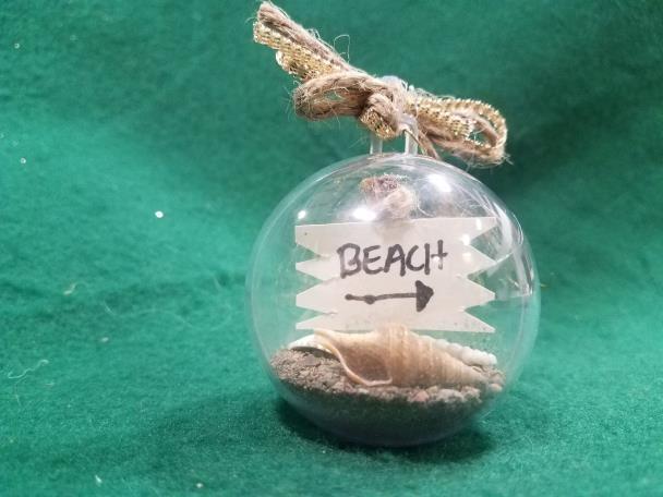 Take ½ of clear plastic bulb, add sand and shells 3. Glue sign to stick 4.