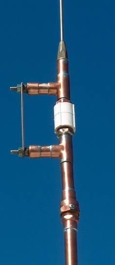 The Center Insulator and Coil Mounts. The lower section of the antenna is a 1/2" diameter copper pipe about 60 cm (24 inches) long that extends upward to the lower coil support.