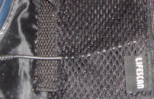 3) Thread the cable through the mesh pocket, in through the zippered opening and out through