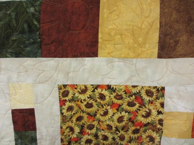 gold metallic in the border. Her sister-in-law, Kristine Berg, added the beautiful sunflower quilting design.