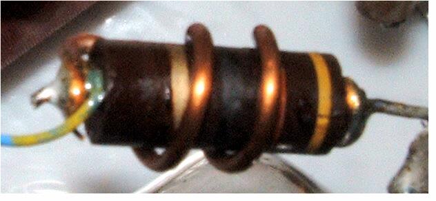 The coil is mounted between the insulator that used to hold the plate blocking capacitor (C-14) and pin 2 of the nearest 572B tubes.