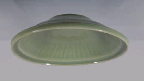 11. A Chinese celadon dish, sturdily potted with a tapered foot, the centre with a flower and bordered with radiating lines, covered overall with an even translucent glaze of soft sea-green