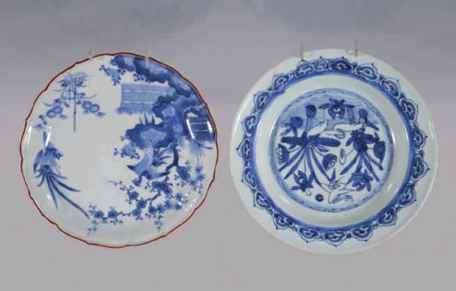 15. A Japanese porcelain Arita barbed blue and white dish, painted with a Ho-Ho bird perched on a rock, and an opposing bird flying opposite, with brown