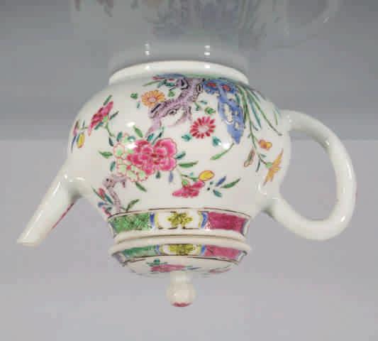 39. A Chinese famille rose squat baluster shaped teapot and cover, with loop handle and ball knop, finely painted with two figures in a