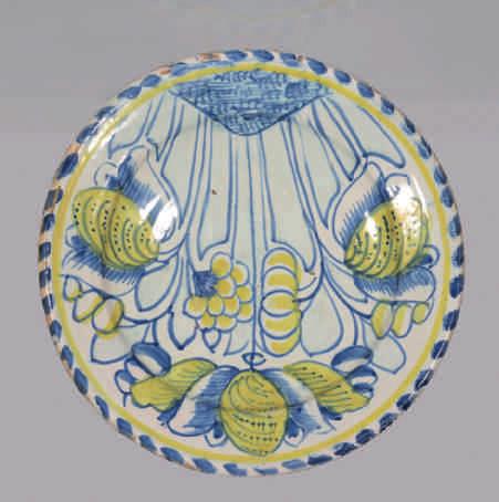 58. A superb English Delft blue dash charger, painted in yellow and blue with three tulips, a lily and other flowers and buds, the reverse with a pinkish tin