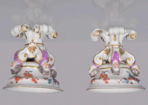 65. A rare pair of Meissen oval salt cellars, each bowl painted in Japanese Kakiemon palette with flowers and leaves to the interior and exterior, on four scroll shaped supports each