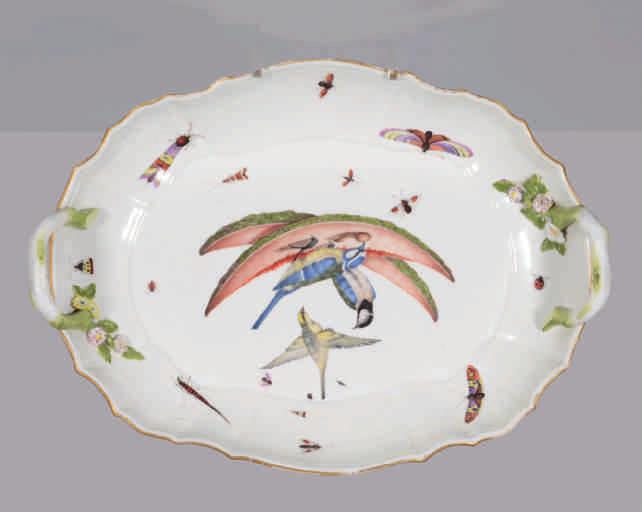 69. A Meissen oval dish, the two twig loop handles with applied flower and leaf terminals, finely painted in coloured enamels with two Blue Tits pecking at