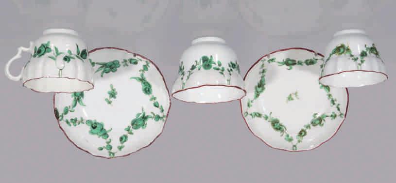 108. A Bristol ogee shaped coffee cup and saucer, the cup with laurel moulded ear shaped handle, painted in green and black with floral garlands, suspended from rings, within brown line borders,