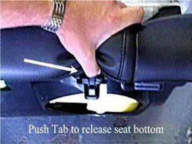 1) Remove rear seat bottom cushion by lifting upward while depressing two retainer tabs, located directly below seat cushion; one per side.