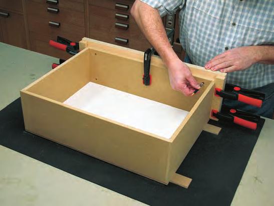 To mount the drawer faces, align and clamp them to the drawers and mark the pilot hole locations for the drawer-face mounting screws as shown in photo 9, below.