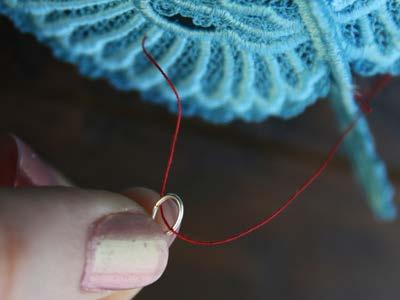 Then, go through the jump ring with the threaded needle, so that the thread running