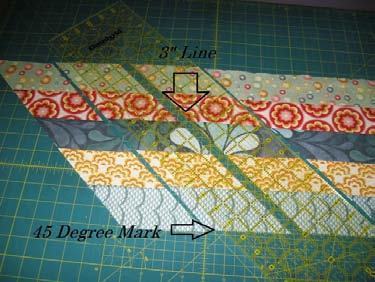 Place a long 6" wide ruler so that the opposite 45 degree mark is aligned with the bottom of your first strip and the edge of the ruler