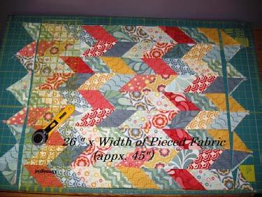Now fold the entire pieced work in half and lay it on your cutting mat aligning the folded edge with the 0 horizontal line of your mat.