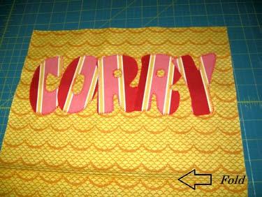 to the outside of the bag. First lets add the front pocket. So grab your folded 12" x 18" rectangle and your remaining applique yardage. Applique your Family Name.
