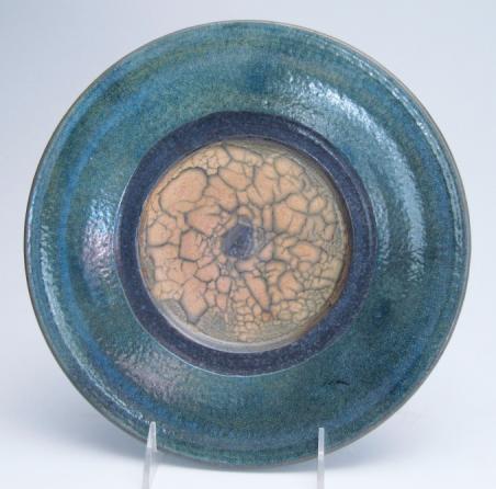 $95 336 Raku Plate, soft light orange with dark crackle pattern in the center surrounded by a carbon black band, lustrous dark turquoise