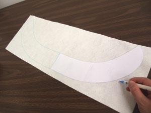Now it's time to prepare the fabric for the brim. Lay the brim pattern piece on the fabric and trace the shape.