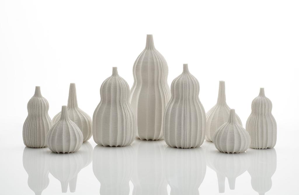 ANDREW WICKS Garniture of Nine Vases, 2018 Thrown and carved porcelain Height 33cm (13 ) Width 75cm (29 1 / 2 ) Depth 34cm (13 3 / 8 ) 11,800 HIROSHI SUZUKI Seni Vase, 2015 (left) Hammer-raised and