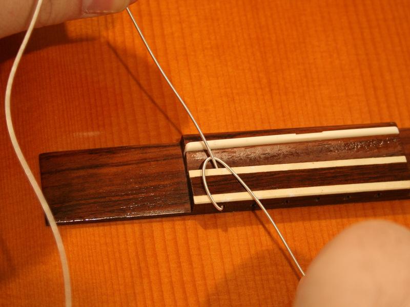 Step 3 Thread strings through the bridge The first three strings (low E, A, and D), have thick and springy ends; the three