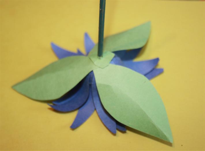 For these leaves, I chose a light green paper. I decided upon 3 pointed leaf shapes and glued them onto the flower, using the same method as on page 10.