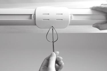 Remove the paper backing on one side of the hook and loop fastener dots. Apply the dots to the installation brackets on each end of the shading.