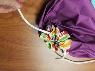 and tie the ends of the cord in place near the drawstring pocket openings.