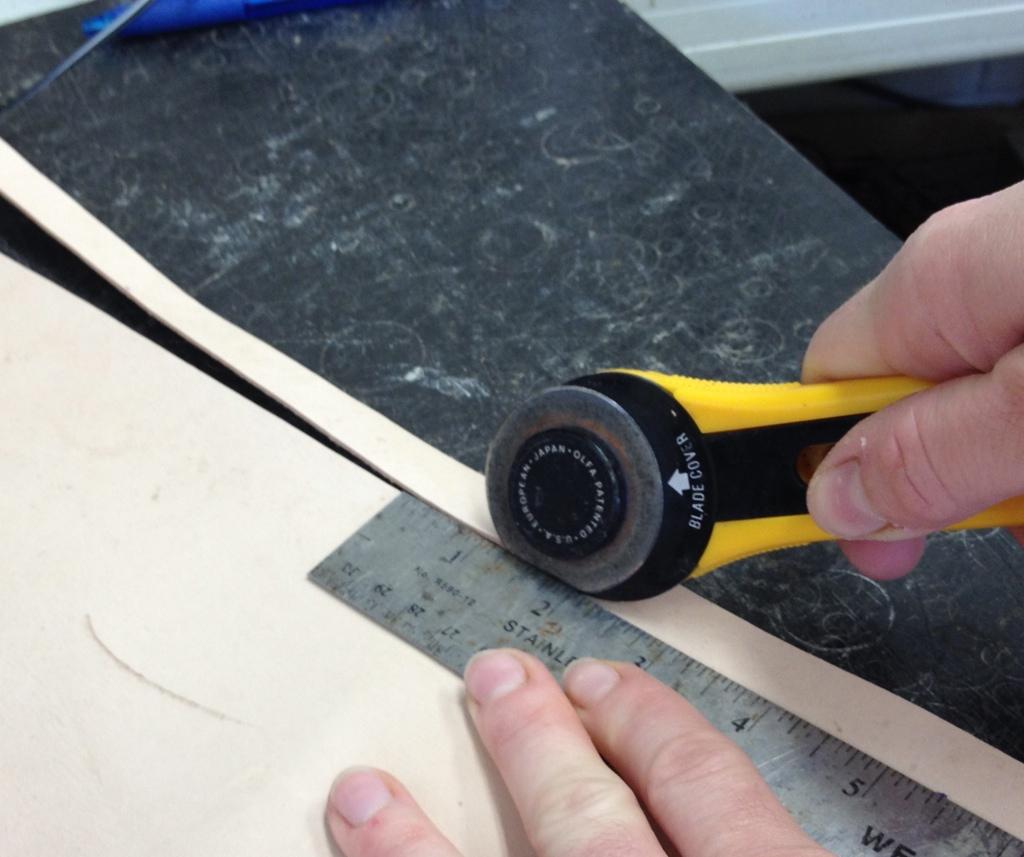 Using the leather cutter or X-ACTO Knife, cut the strip along your marks the entire length of the hide trying to keep the width as uniform as possible.
