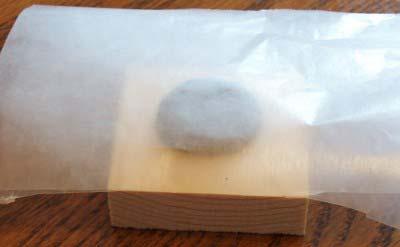 Here we set the clay ball on the wax paper which is on the block of