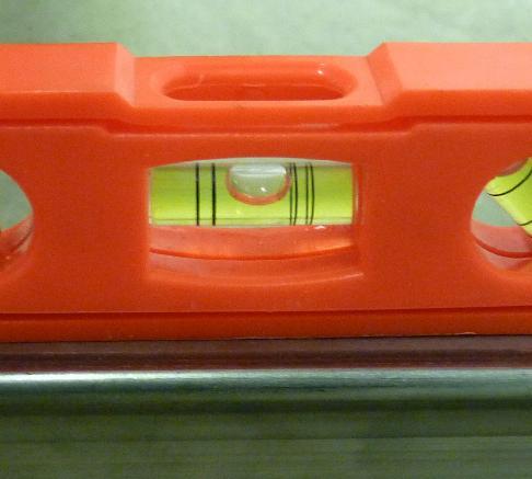 Place the included torpedo level on the leg of the saw. Notice how the bubble is touching the first line on the right.