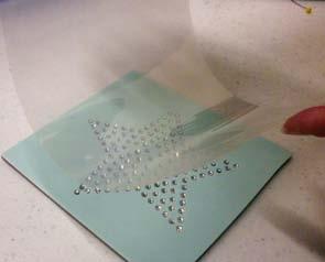 Carefully peel the rhinestone template material away from the parchment paper and place on a piece of rhinestone template backboard. Smooth into place. 13.