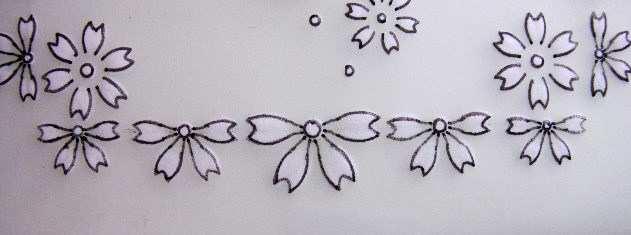 Step 10: Using the black micron pen add lines to make the half flowers around the border look like bows as shown.