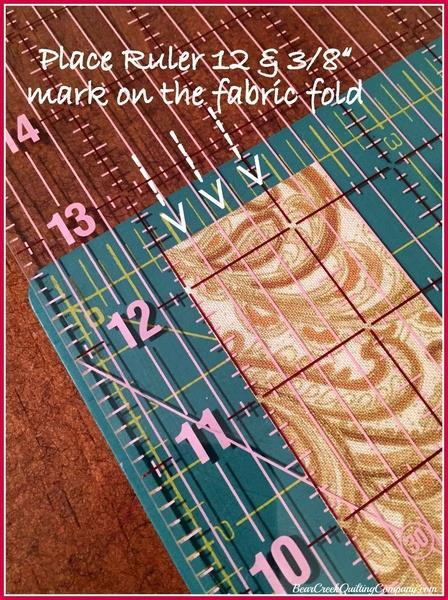 Place the ruler on the fabric fold with the "1/2 the total length"