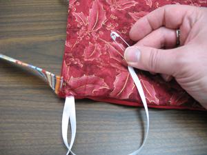 To add the drawstrings, cut two pieces of 1/4 inch ribbon 22 inches long.