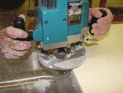 Adjust the height of the bit in the router until it is cutting as much of the solid surface away as