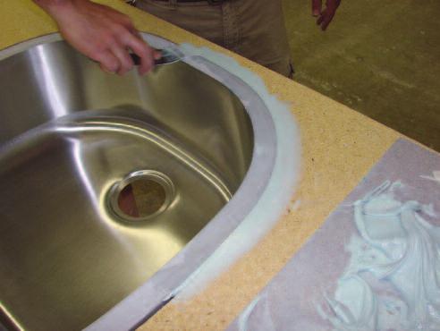 Mix up Bondo or similar body filler product. Smear Bondo into the gap around the sink.