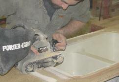 STEP 8 Once hard, use a belt sander with a coarse grit sandpaper to sand the rim of the sink and the Bondo.