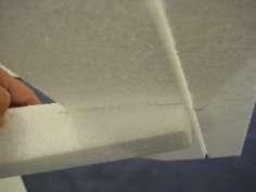 Put hot glue on the recessed surface of the fuselage (where you cut out a portion), and