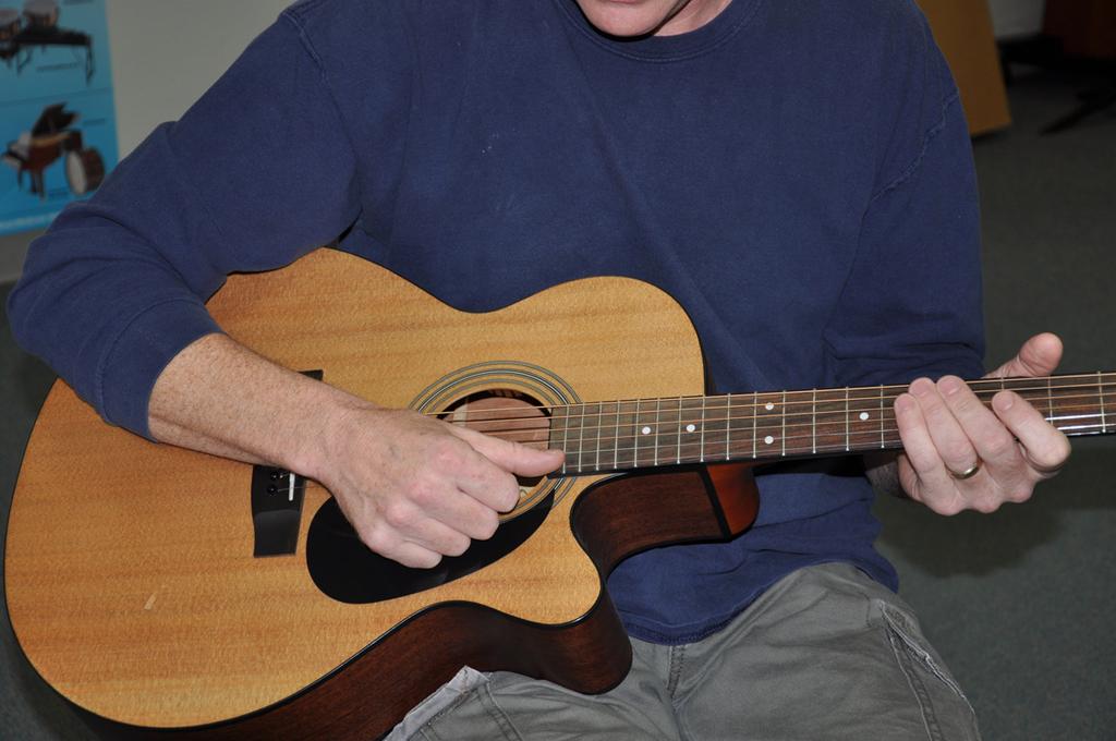 Student Strummers by Ben Porter Holding the guitar - the curved part of the guitar should rest comfortably on your right leg, and your right elbow should rest opposite your leg on the side of the