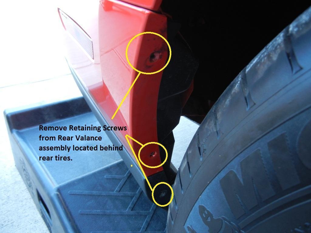 g. Move to the rear wheel well and locate three retaining screws just behind the rear tires.