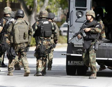 Officers may not be wearing traditional police uniforms Instead they may be in tactical gear with rifles, helmets and ballistic vests To