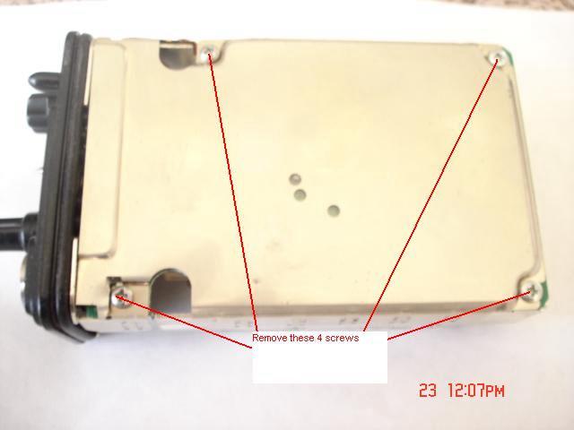 8. Turn the radio over so the back metal shield/cover is facing up and remove the 4 screws